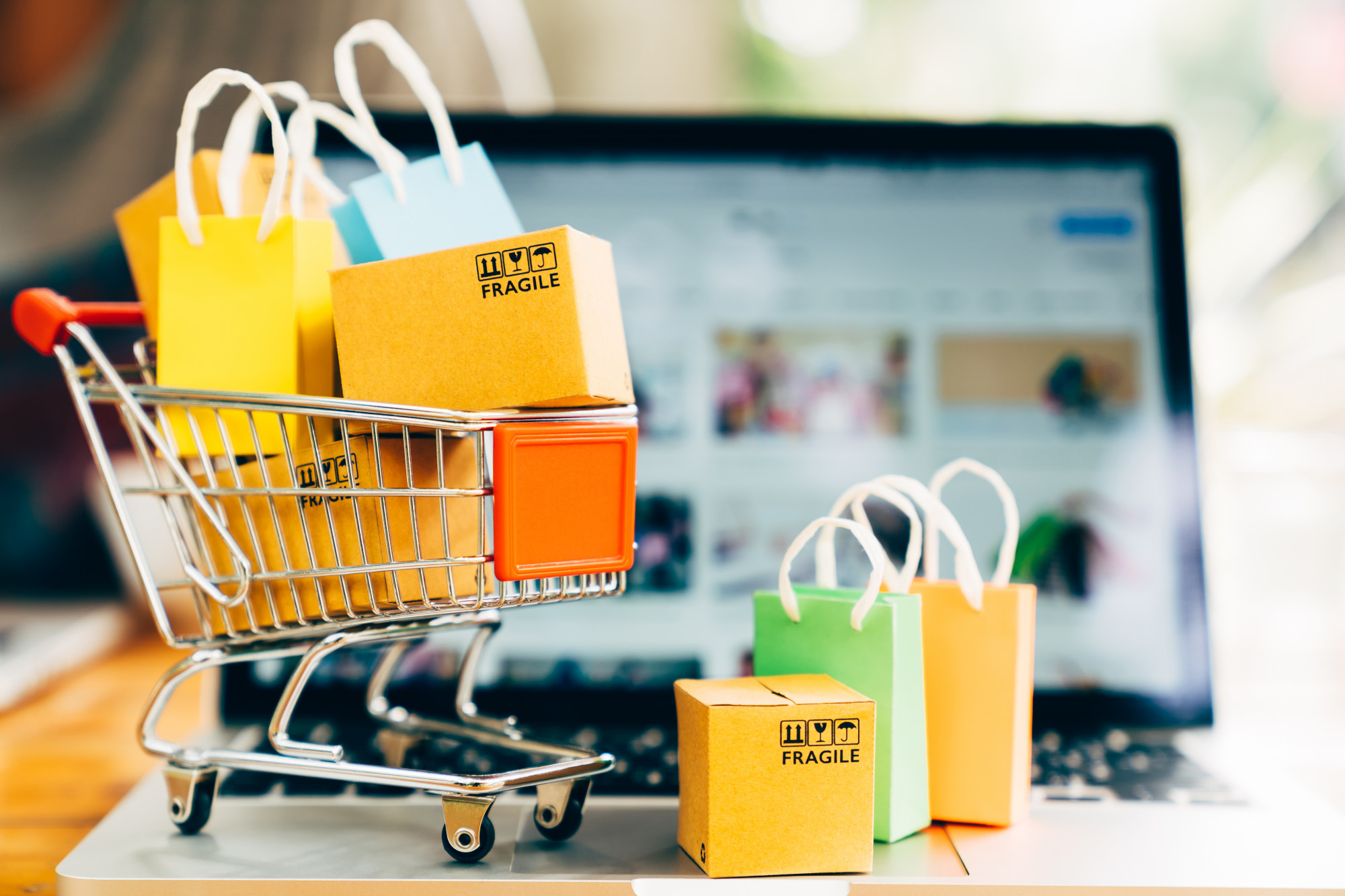 Produktpaketboxen-Einkaufstaschenwagen-mit-Laptop-Online-Shopping-Lieferkonzept