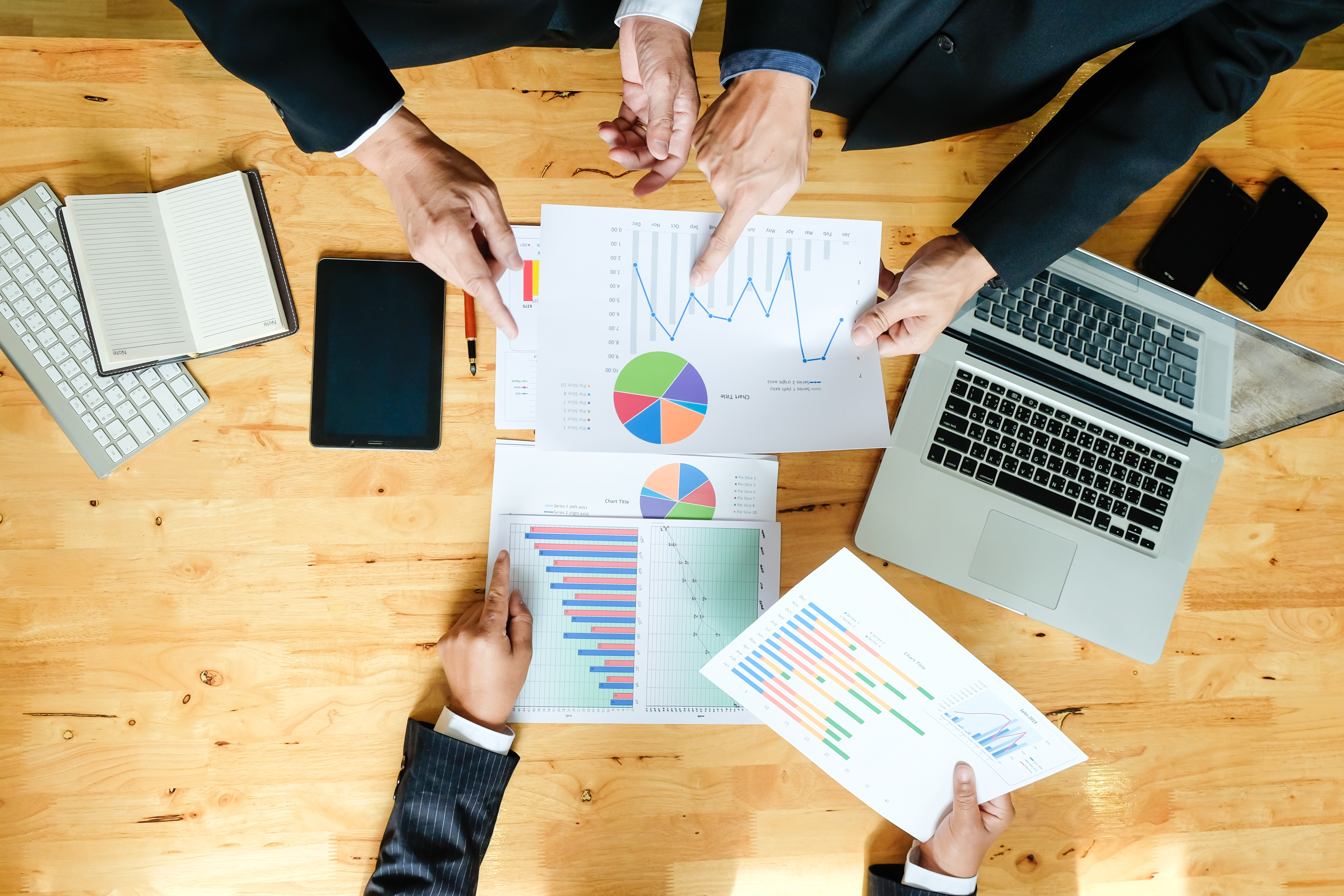 فريق عمل يعمل على خطة عمل جديدة باستخدام كمبيوتر رقمي حديث. لقطة منظر علوي.